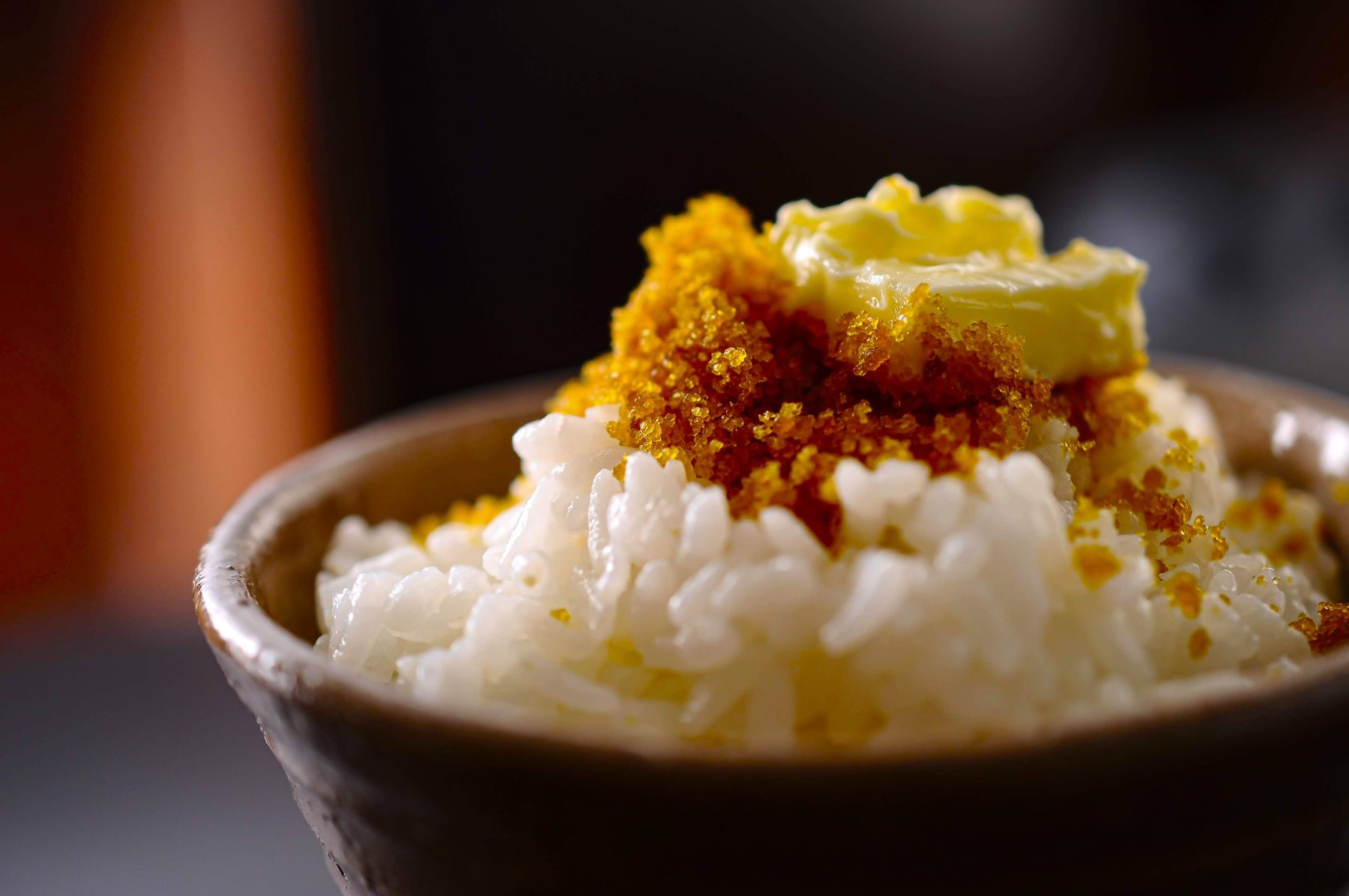 炊いたごはんに、バターとからすみパウダーをのせた茶碗